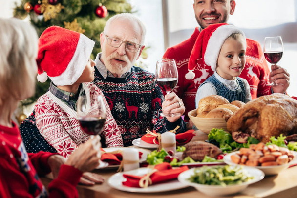 senior man with wine glass making toast during christmas celebration with family at home  - Photo, Image