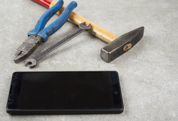 Do not fix your mobile phone with hammer pair of players or an wrench - Valokuva, kuva