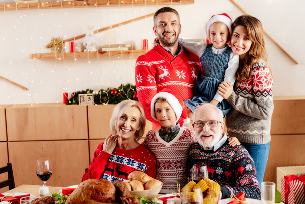 famille souriante célébrant Noël à table avec dîner de vacances à la maison
 - Photo, image