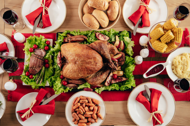 vista elevada de la mesa servida con deliciosos platos y vino para la cena de vacaciones en Acción de Gracias
  - Foto, imagen