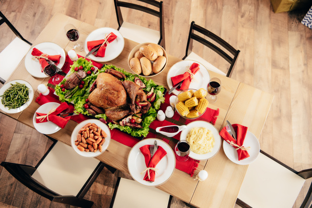 вид зверху сервірованого столу зі смачними стравами та вином на святкову вечерю на подяку
  - Фото, зображення