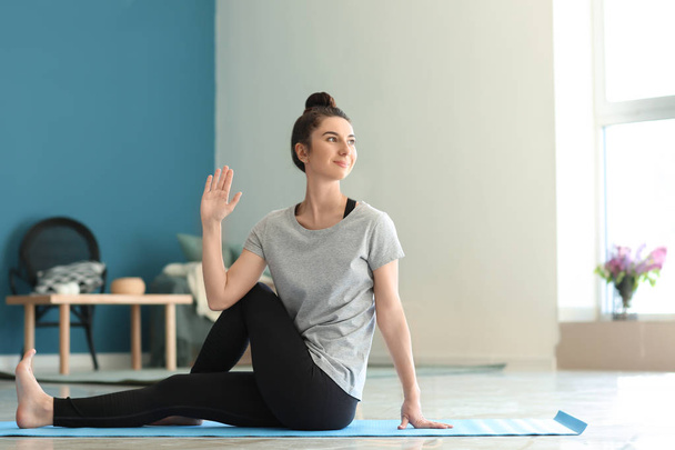 Jeune femme pratiquant le yoga à la maison - Photo, image