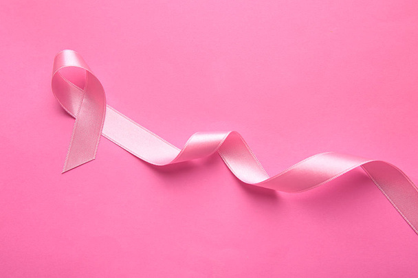 Pink ribbon on color background. Breast cancer concept - 写真・画像