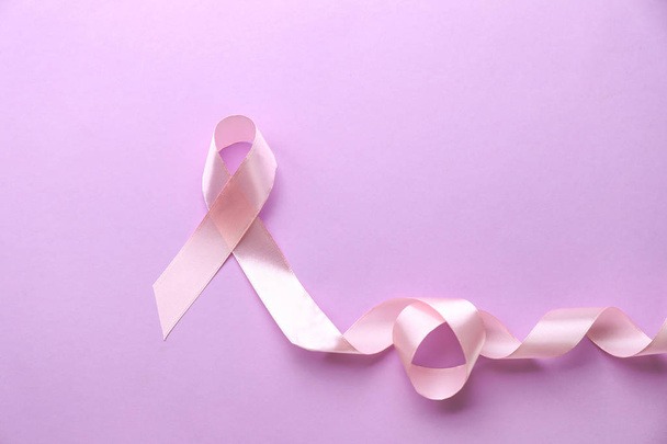Pink ribbon on color background. Breast cancer concept - Photo, image