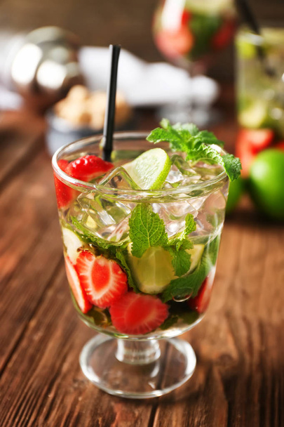 Glass of fresh strawberry mojito on wooden table - Foto, Imagen