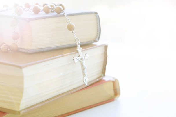 Catholic rosary beads with old book on cement table prayer, rosary background concept in vintage tone. - Photo, Image