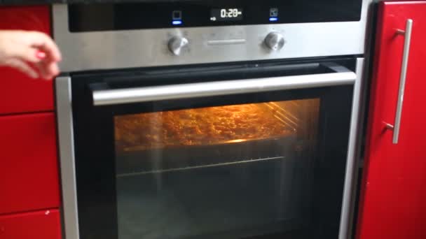 Zbliżenie na kobiece otwarcie piecu w kuchni i grillowanie pizza lub zapiekanka. - Materiał filmowy, wideo