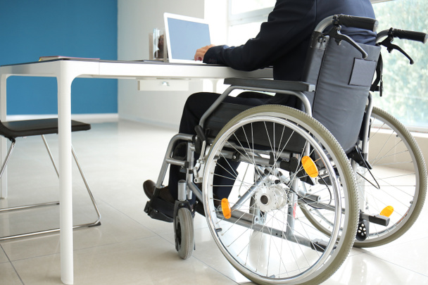 Businessman in wheelchair working in office - Photo, Image