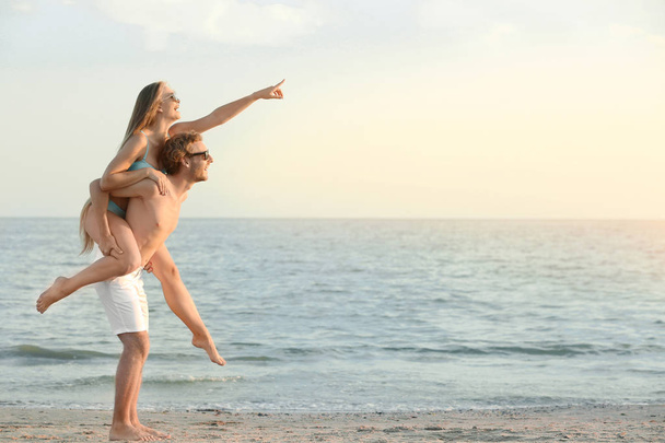 Счастливая молодая пара веселится на морском курорте
 - Фото, изображение