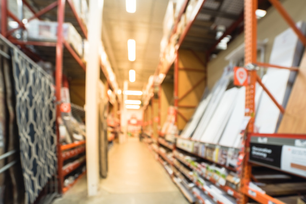 Blurred a large hardware store. Defocused interior of home improvement retailer with aisles, shelves and racks of merchandise tool for house repair from floor to ceiling. Inventory, wholesale concept - Photo, Image