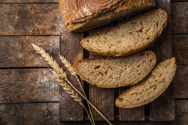 szelet friss sült savanyú azt dought kenyér rusztikus fa háttér, felülnézet - Fotó, kép