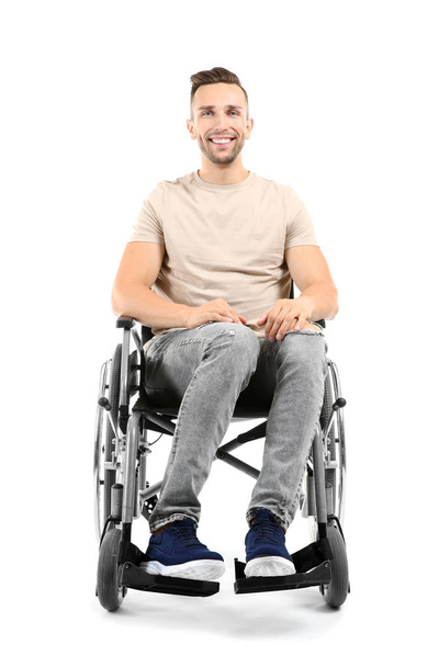 Young man sitting in wheelchair on white background - Foto, afbeelding