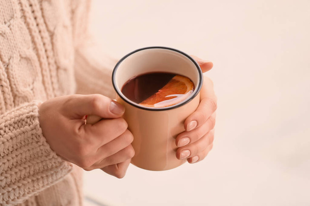 Woman holding metal cup of delicious mulled wine, closeup - Foto, imagen