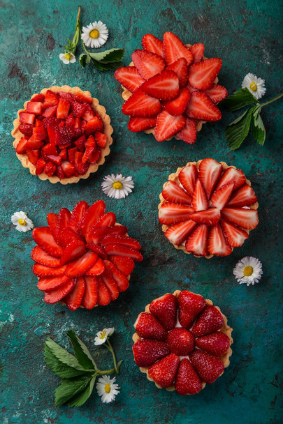 delicious strawberry tarts on green background, top view - Foto, Bild