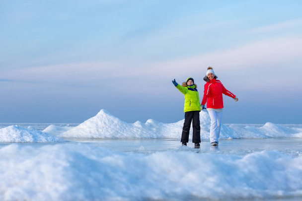 Young mother and her son on icy beach - Foto, Bild