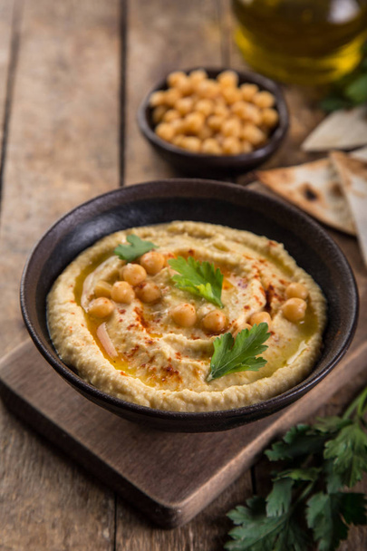 healthy homemade chickpea hummus with olive oil and smoked paprika, wooden background, selective focus - Φωτογραφία, εικόνα