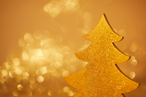 χρυσό λαμπερό χριστουγεννιάτικο δέντρο για διακόσμηση σε θολή φόντο - Φωτογραφία, εικόνα