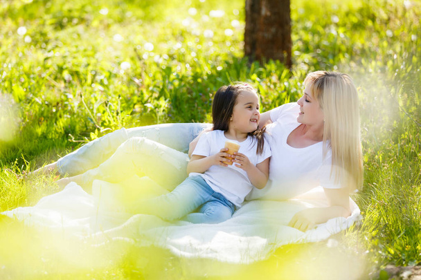 幸せママと小さな娘は緑豊かな公園で休んでアイス クリーム - 写真・画像