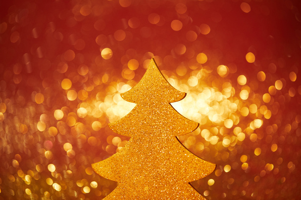 golden glittering christmas tree for decoration on red background - Foto, imagen