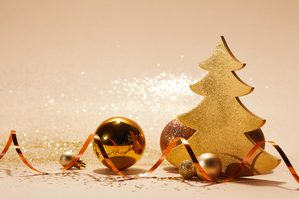 christmas balls, decorative christmas tree, wavy ribbon and glitter on tabletop - Foto, imagen