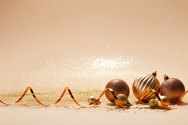輝く明るいクリスマス ボールとベージュの卓上に波状リボン - 写真・画像