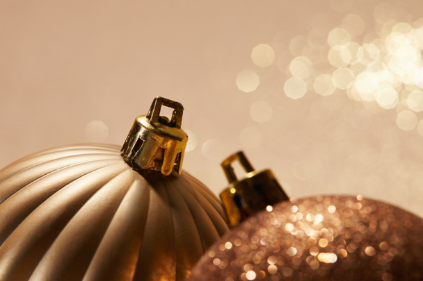 close up of sparkling bright christmas balls on beige background - Fotó, kép