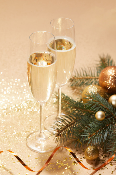golden christmas balls, pine branch and glasses of champagne on tabletop - Photo, Image