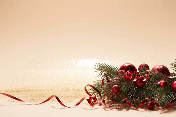 червоні блискучі різдвяні кульки та гілка сосни на стільниці
 - Фото, зображення