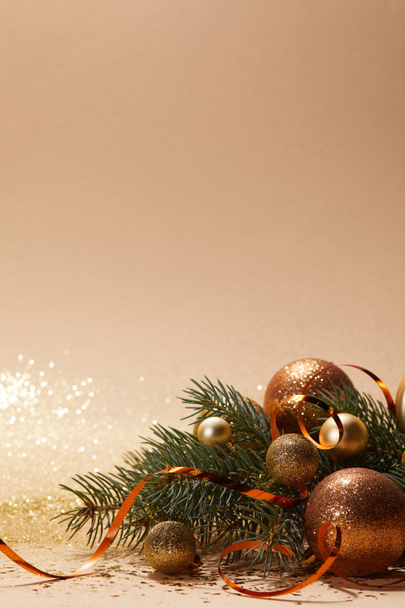 boules de Noël dorées scintillantes et branche d'arbre de Noël sur la table
 - Photo, image
