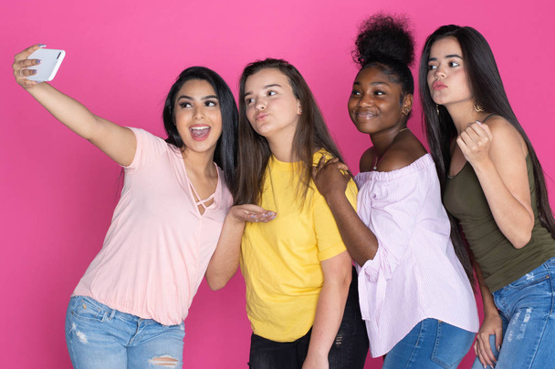 Group of diverse teen together on a pink background - Fotó, kép