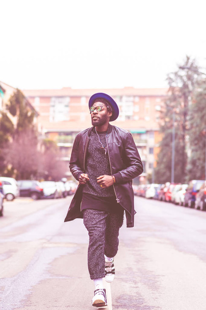 young bearded african man outdoors walking looking away - swag, street style, hip-hop concept - Fotoğraf, Görsel