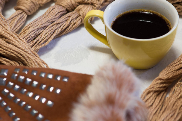 Чашка горячего кофе в день зимнего холода. Теплый шарф и варежки коричневые.
. - Фото, изображение