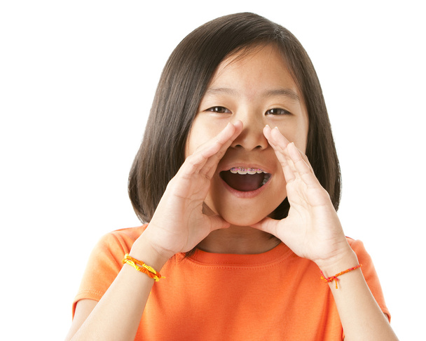 Asian girl holding her hands to her mouth and yelling or cheers - 写真・画像