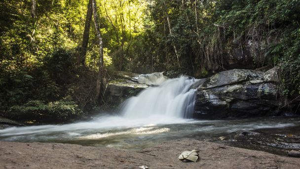 Longa exposição de adorável, pequena cachoeira cercada por exuberante folhagem verde em Mae Klang Luang. Chiang Mai, Tailândia
. - Fotografia, imagem