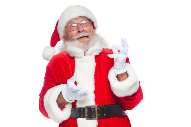 Christmas. Good Santa Claus in white gloves shows faces, grimaces, shows his tongue. Not standard behavior. Isolated on white background. - Photo, Image