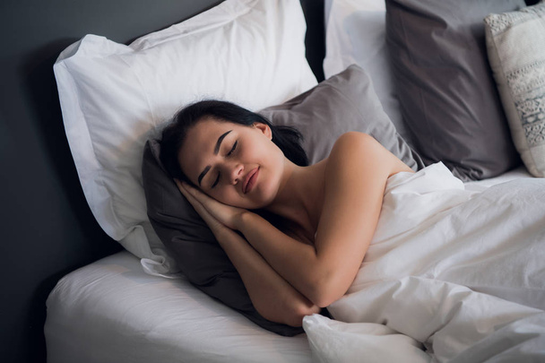 Szállás, utazás és a boldogság fogalmát - gyönyörű nő az ágyban alszik - Fotó, kép