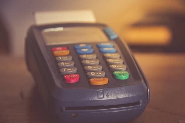 POS payment terminal on wooden background. - 写真・画像