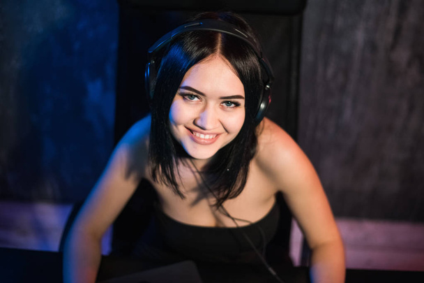 Beautiful Friendly Pro Gamer Girl Does Video Game Gameplay stream, Wearing Headset Talks and Chats with Her Fans and Team into Headphones Microphone. Teenagers Having Fun. Background Neon Retro Colors - Photo, Image