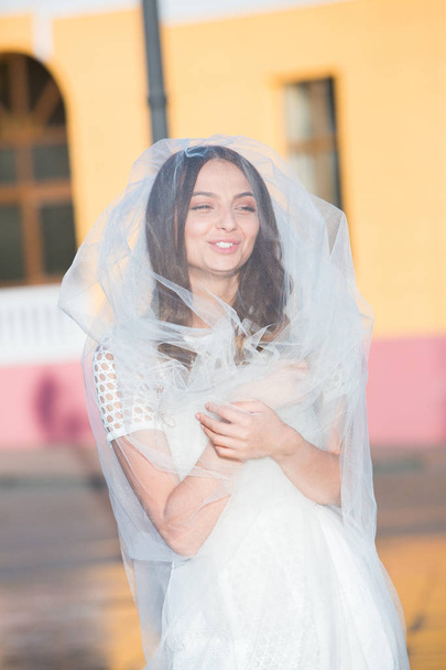 Foto de moda de una hermosa novia. Novia feliz en un vestido blanco con estilo. Novia de boda con estilo con ramo y vestido moderno increíble
. - Foto, Imagen