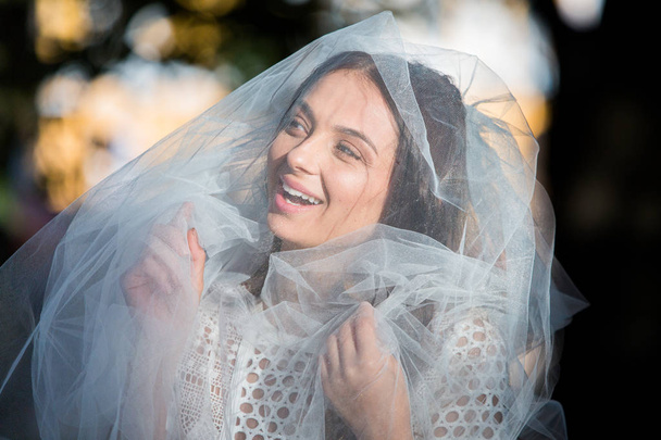 Fashion photo of a beautiful bride. Happy bride in a stylish white dress. Stylish wedding bride with bouquet and amazing modern dress. - Foto, Imagen