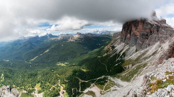 paisagem montanhosa pitoresca no Gardena de Val em Alta Badia nas Dolomitas de Itália com dois alpinistas e uma cabana montesa abaixo
 - Foto, Imagem