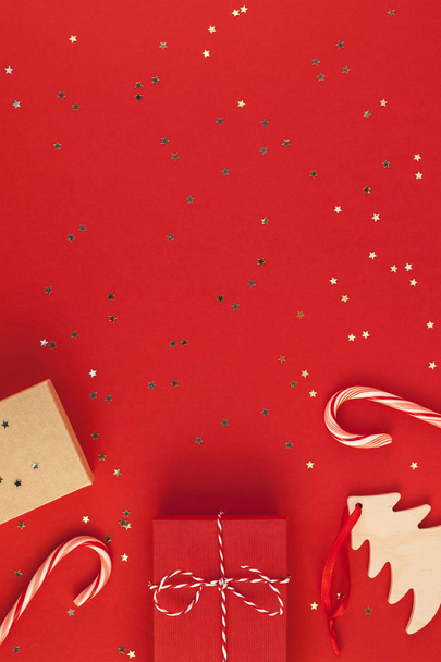 Yeni yıl Noel hediyelerini sarılı şerit düz üstten görünüm Xmas 2019 tatil kutlama el yapımı hediye kutu kırmızı kağıt altın sparkles arka plan boşaltmak yatıyordu. Mockup tebrik kartı metin tasarım şablonu - Fotoğraf, Görsel