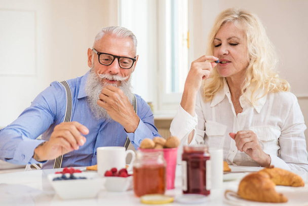 Happy senior couple having breakfast at home - Married couple on the 60's in their apartment, concepts about senority and relationship - Foto, Bild