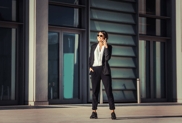 Beautiful businesswoman walking outdoors - Pretty young adult female - Fotó, kép