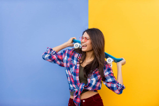 Portrait of stylish pretty girl on colored background - Happy woman with urban styled attire, concepts about lifestyle and youth - Foto, imagen