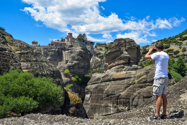 Людина фотографування монастир Святого Миколая Anapavsas (Joyous), розташований на скелі метеора, Греція. - Фото, зображення