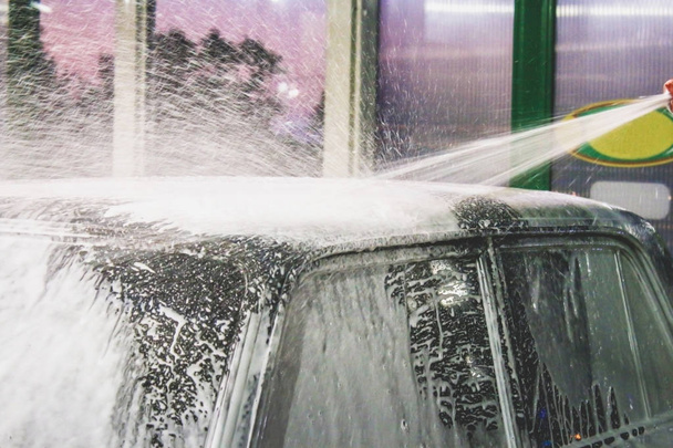 Man washes foam machine. Carwash. Washing machine at the station - Photo, Image