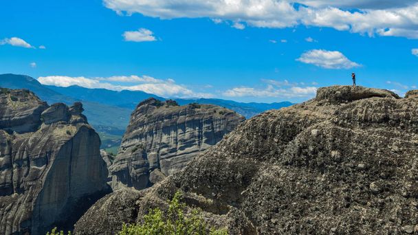 De man op de achtergrond van de rotsen waarop de kloosters van Meteora zich bevinden. - Foto, afbeelding