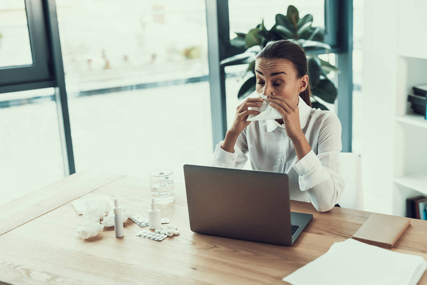 Young Sick Woman in White Shirt Sitting in Office.Healthcare Concept. Modern Office. Sick Worker. Healthcare in Office. Wooden Table. Digital Device. Laptop on Desk. Young Woman in Office. - Foto, imagen
