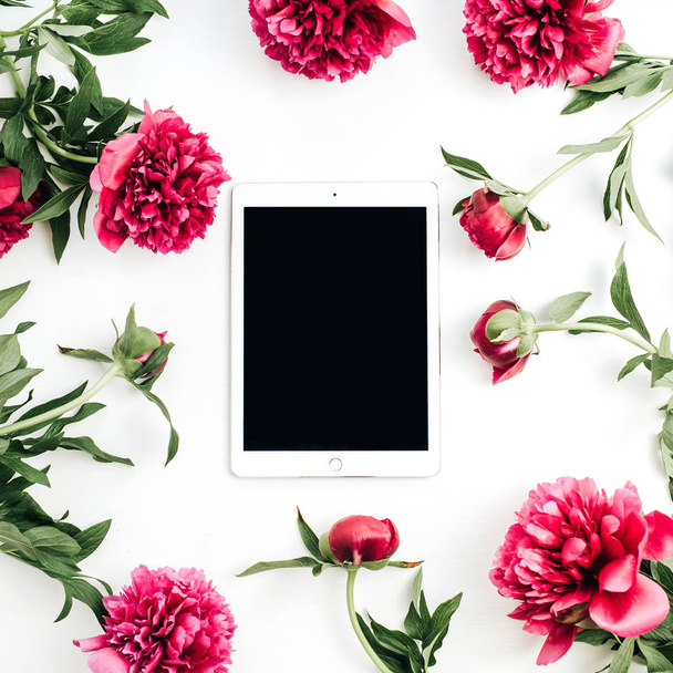 Fehér alapon Tablet és a bazsarózsa virágok. Modell akár lakás feküdt, top view. - Fotó, kép